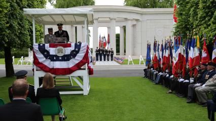 A man in uniform delivers remarks from the podium during the ceremony. 