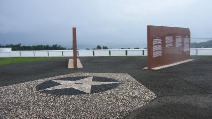 Two of the marble walls of the memorial are seen at an angle. Water is visible in the distance.