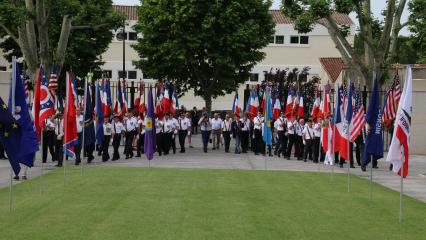 Men and women march in during the ceremony, each bearing a flag. 