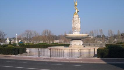 The Tours American Monument, a white stone fountain with a gold statue of an American Indian holding an eagle.