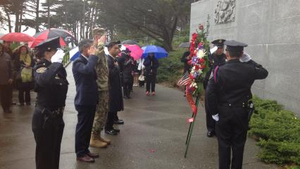 People salute after laying a wreath at the memorial. 