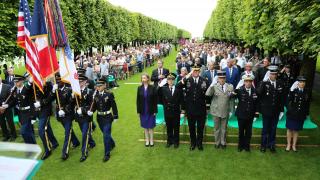 Attendees stand at the beginning of the ceremony. 